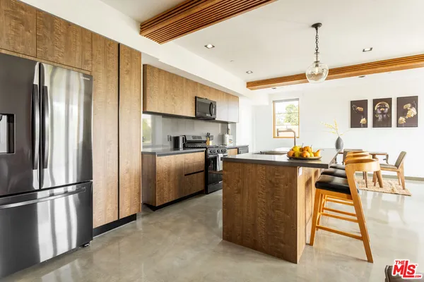 a kitchen with stainless steel appliances granite countertop a refrigerator a stove top oven a sink dishwasher and a refrigerator