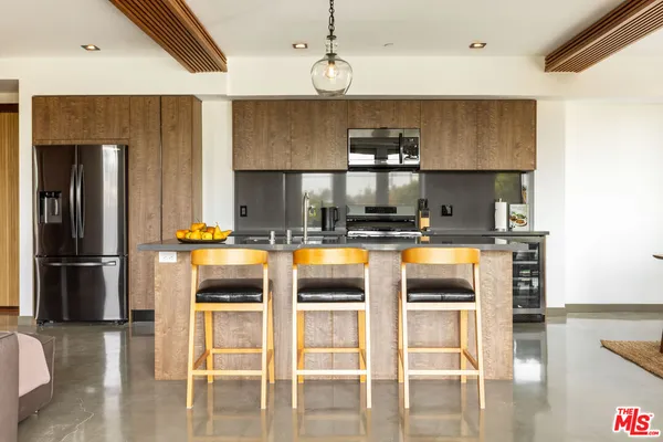 a kitchen with a refrigerator a stove and a dining table with wooden floor