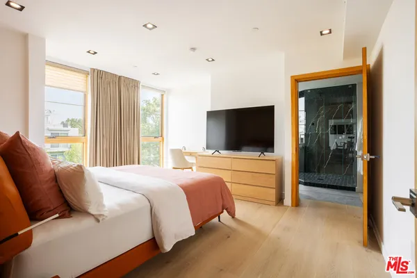 a bedroom with a bed and a flat screen tv