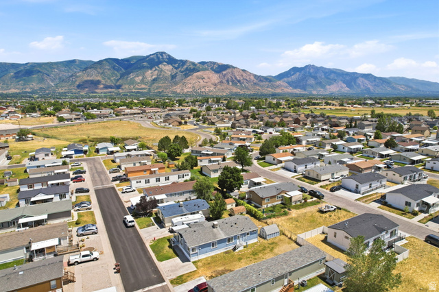 2491 Highway 89, Unit 614 Pleasant View, UT 84404 - Photo 24 of 27 Residential neighborhood with paved streets and mature landscaping, set against a backdrop of distant mountains