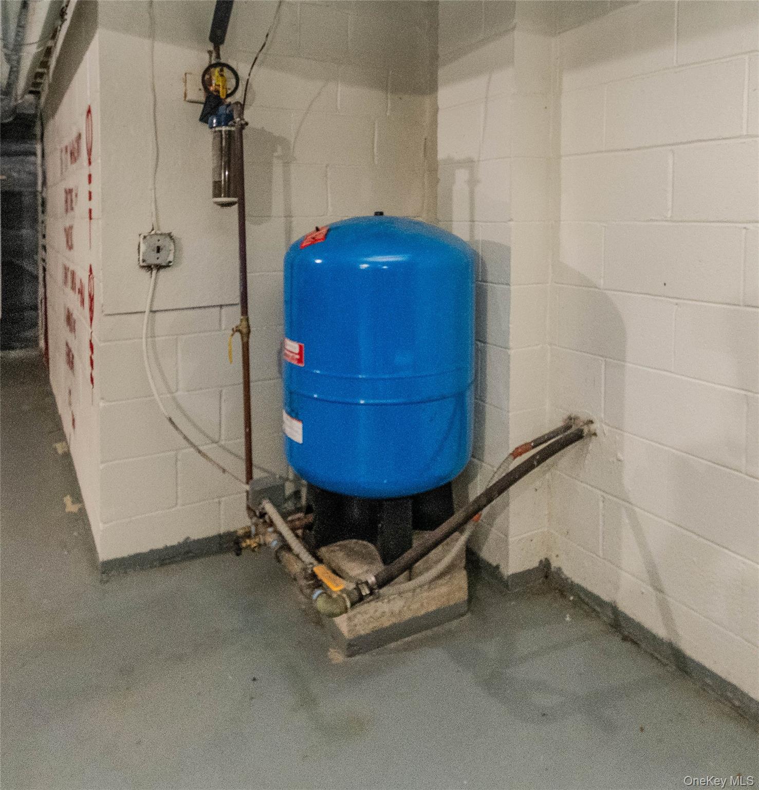 15 Van Dewark Road Middletown, NY 10941 - Photo 30 of 41 Well pressure tank system with associated plumbing, positioned against white painted concrete block walls