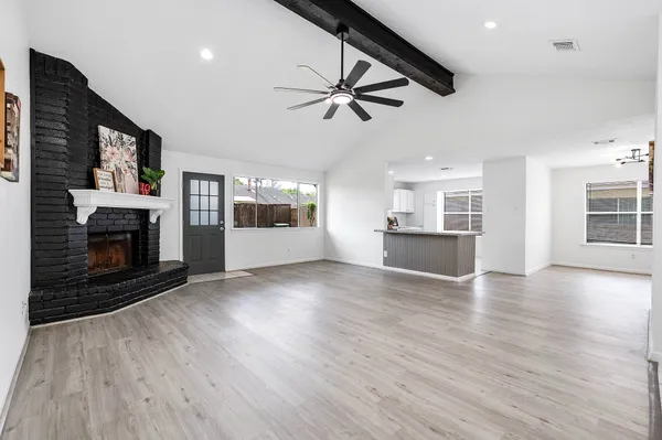 wooden floor fireplace and windows in an empty room