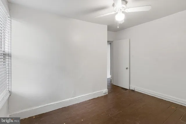 an empty room with a ceiling fan and a window