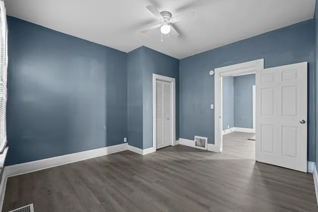 a view of an empty room with wooden floor