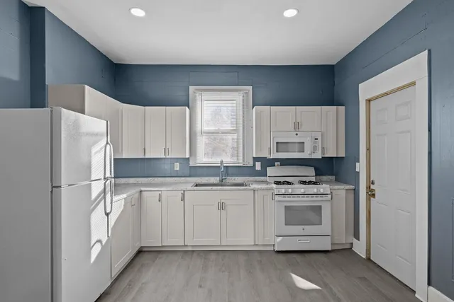 a kitchen with a white cabinets and white appliances