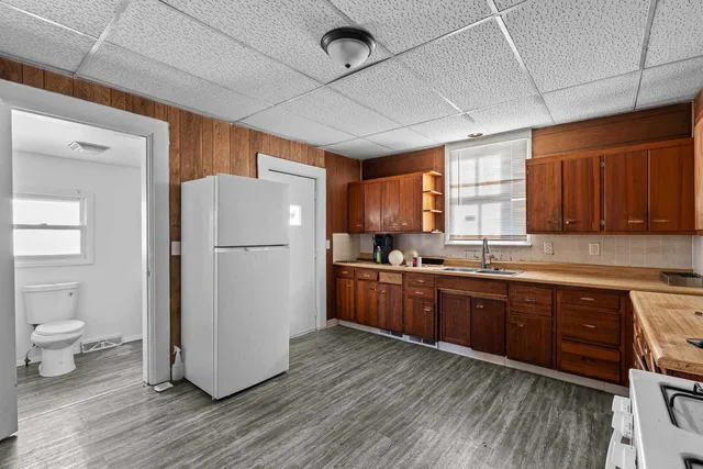 a kitchen with a stove a refrigerator and wooden floor