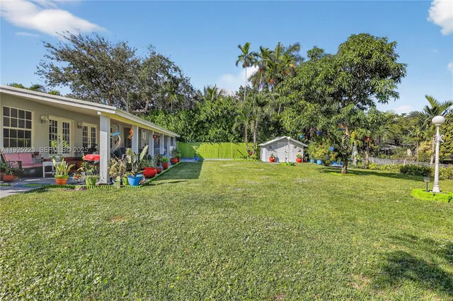 a view of a house with a big yard and potted plants