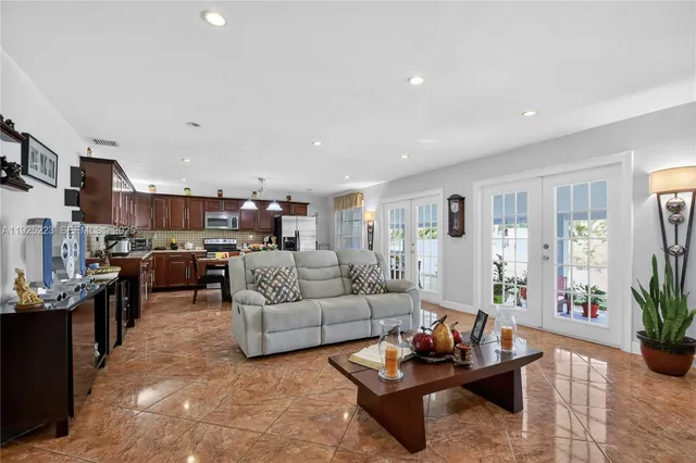 a kitchen with stainless steel appliances granite countertop a stove a sink dishwasher a refrigerator with a dining table and chairs