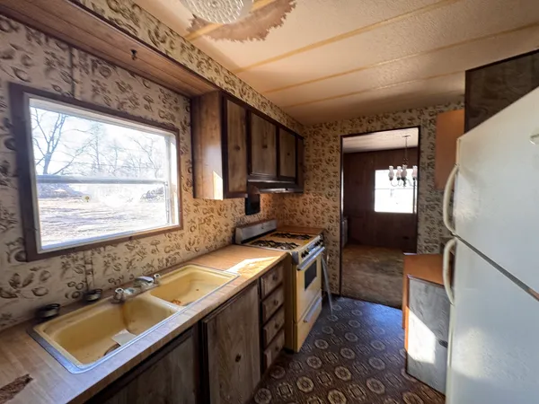 a kitchen with a sink a stove cabinets and a wooden floor
