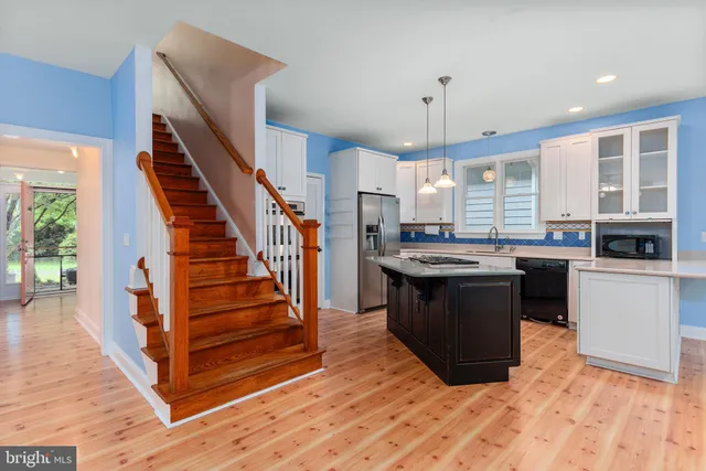 a kitchen with white cabinets appliances a sink and dishwasher