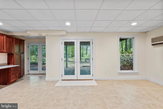 a view of an empty room with cabinet and window