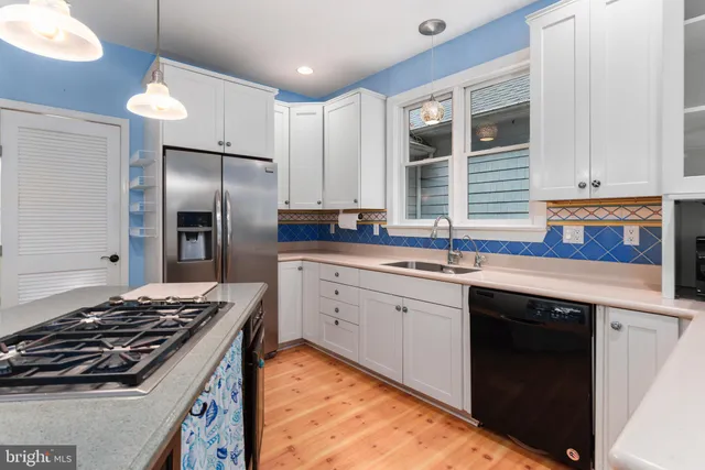 a view of an empty room with wooden floor fireplace and a window