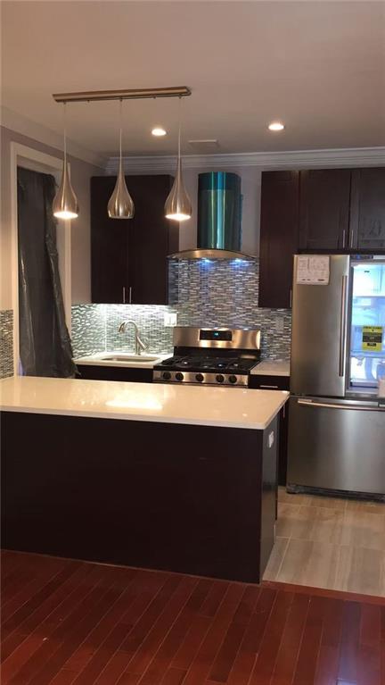 34-37 110th Street Queens, NY 11368 - Photo 4 of 9 a kitchen with kitchen island a counter top space a sink and appliances