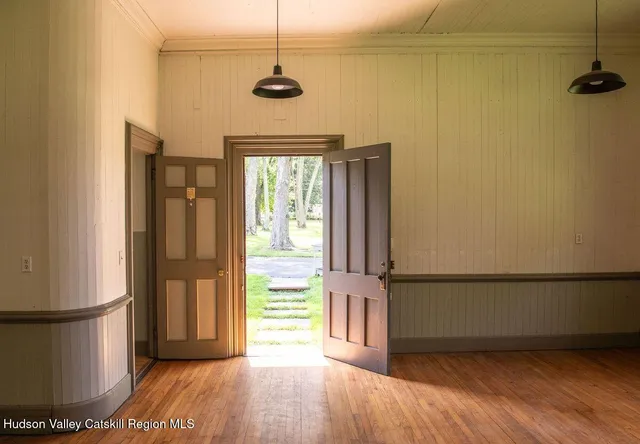 a view of empty room with wooden floor and fan