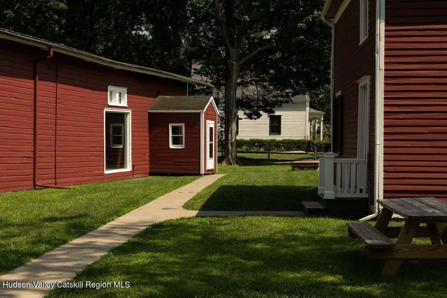 a view of house with backyard outdoor seating area and trees