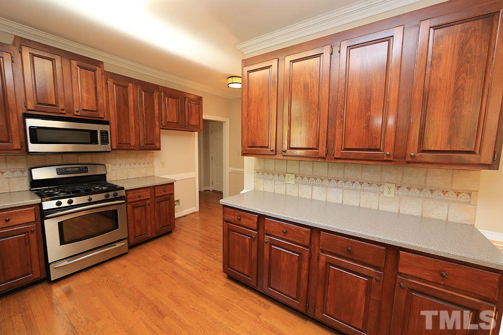 7809 Ketley Court Raleigh, NC 27615 - Photo 9 of 30 Refinished hardwood floors, Stainless Steel appliances, tile back splash and laundry closet around corner as well as 2 closets with shelves.