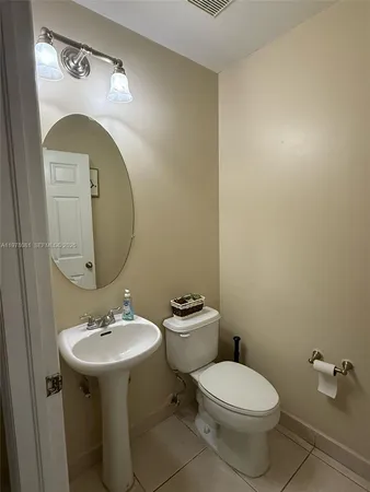a bathroom with a toilet a sink and mirror