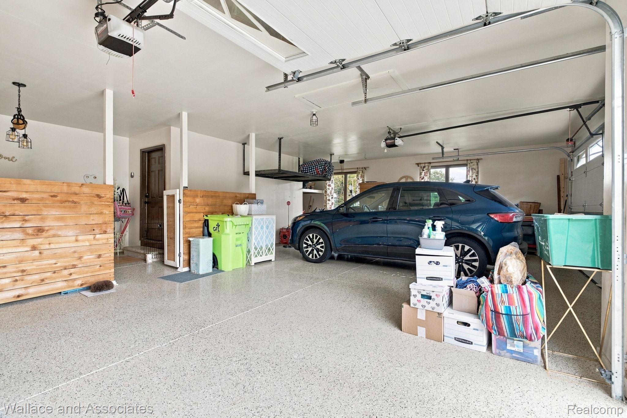 17076 27 Mile Road Ray, MI 48096 - Photo 53 of 63 Spacious garage featuring a durable epoxy floor, overhead track lighting, an automatic garage door opener, and a built-in overhead storage rack