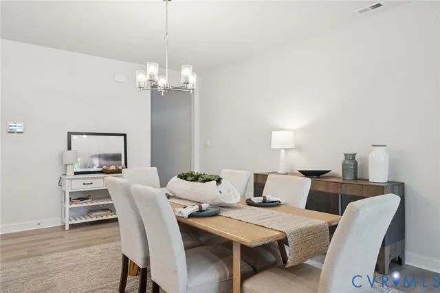 a view of a dining room with furniture and chandelier