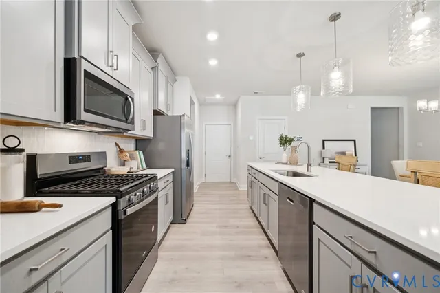 a kitchen with stainless steel appliances a sink stove and cabinets