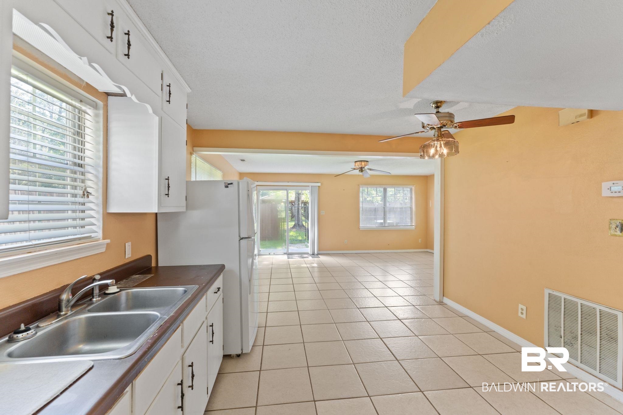 14095 Riverside Drive Foley, AL 36535 - Photo 11 of 30 Kitchen featuring plenty of natural light, a ceiling fan, light tile patterned floors, white cabinetry, and a textured ceiling