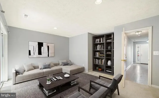 a living room with furniture and a book shelf