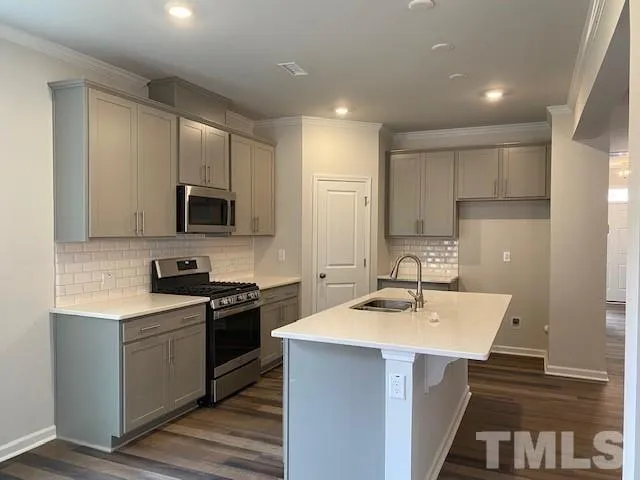 a kitchen with a sink a stove a refrigerator and cabinets