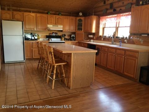1977 County Road 210 Rifle, CO 81650 - Photo 6 of 16 a kitchen with stainless steel appliances a sink a stove a refrigerator cabinets and a dining table with wooden floor
