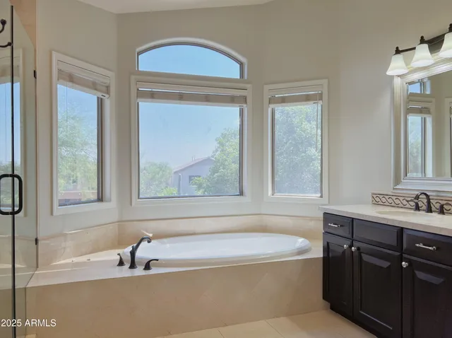 a bathroom with a tub sink and mirror