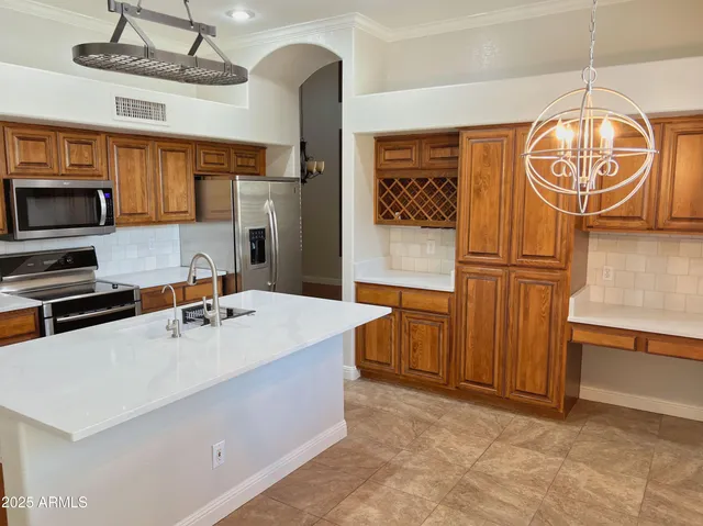 a kitchen with granite countertop a sink a stove and refrigerator