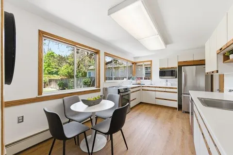 a kitchen with a table chairs refrigerator and microwave