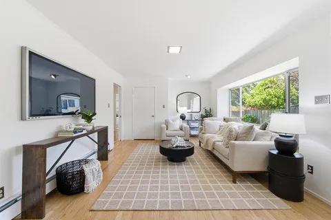 a living room with furniture a rug and a window