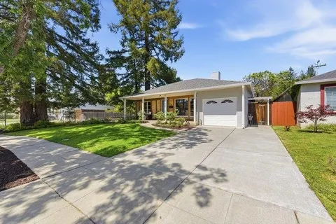 a front view of a house with yard and green space