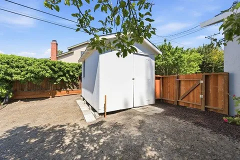 a view of a house with a yard and potted plants