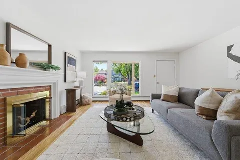 a living room with furniture a fireplace and a large window
