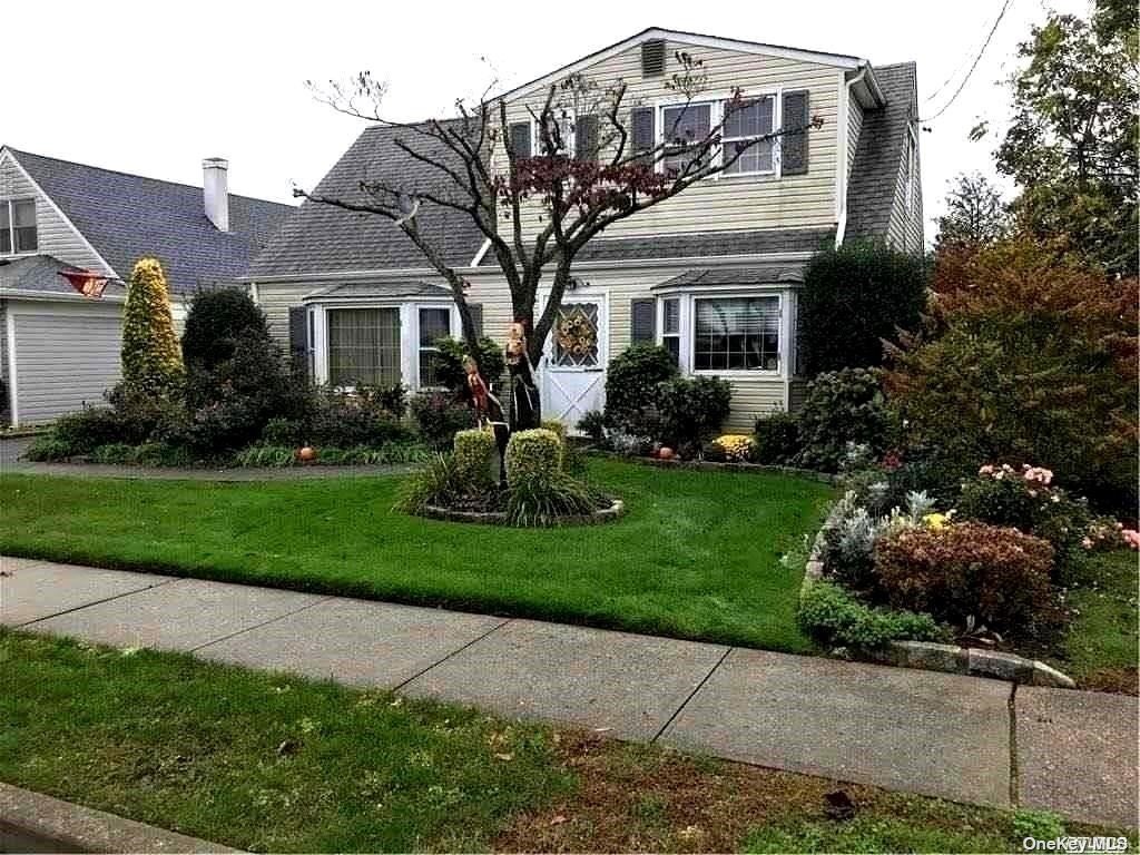 a front view of a house with a yard and potted plants