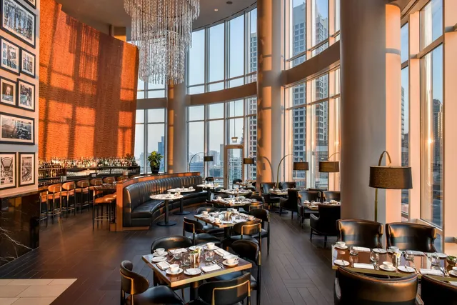 a living room with furniture and floor to ceiling windows and wooden floor