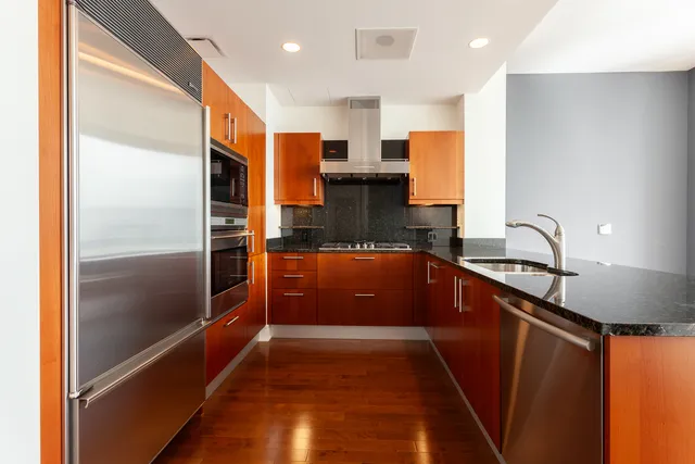a kitchen with stainless steel appliances granite countertop a refrigerator and a sink