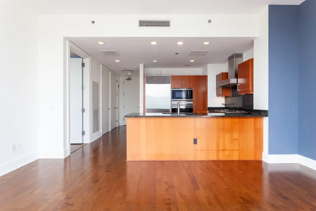 a view of kitchen with stainless steel appliances granite countertop a stove top oven and a refrigerator