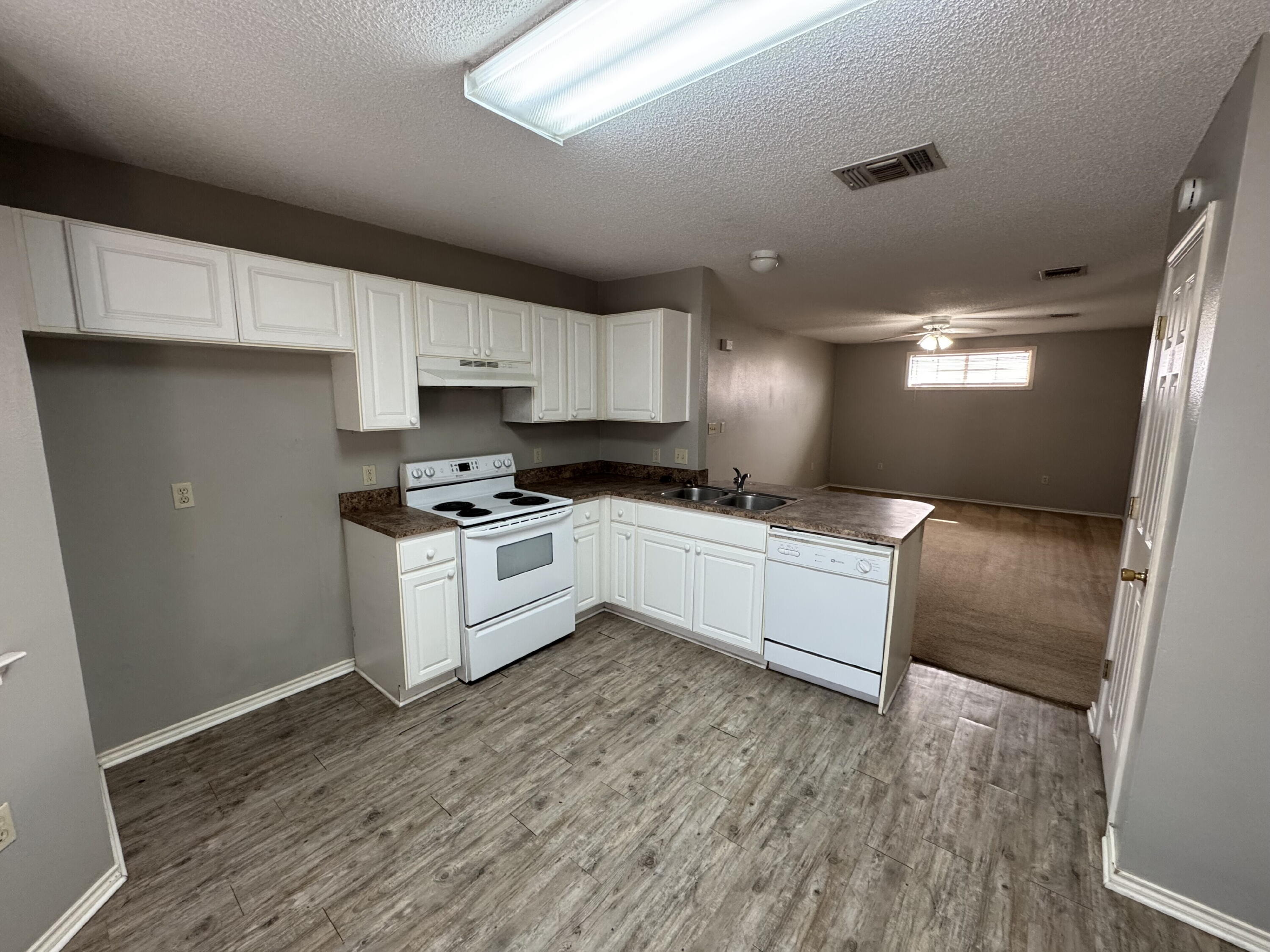 5839 7th Street, Unit D Lubbock, TX 79416 - Photo 4 of 9 a kitchen with a white cabinets and white appliances