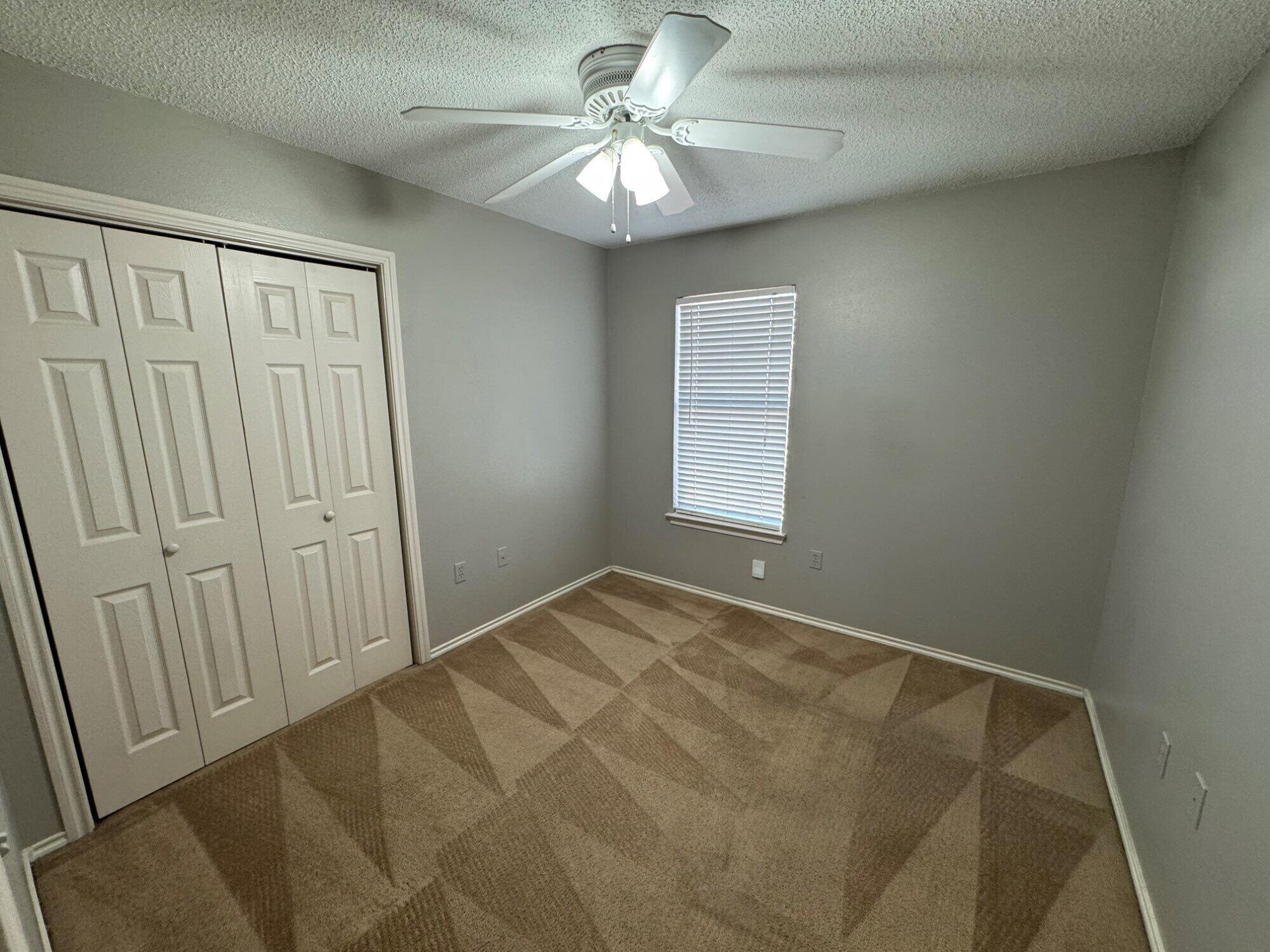 5839 7th Street, Unit D Lubbock, TX 79416 - Photo 5 of 9 an empty room with windows and fan