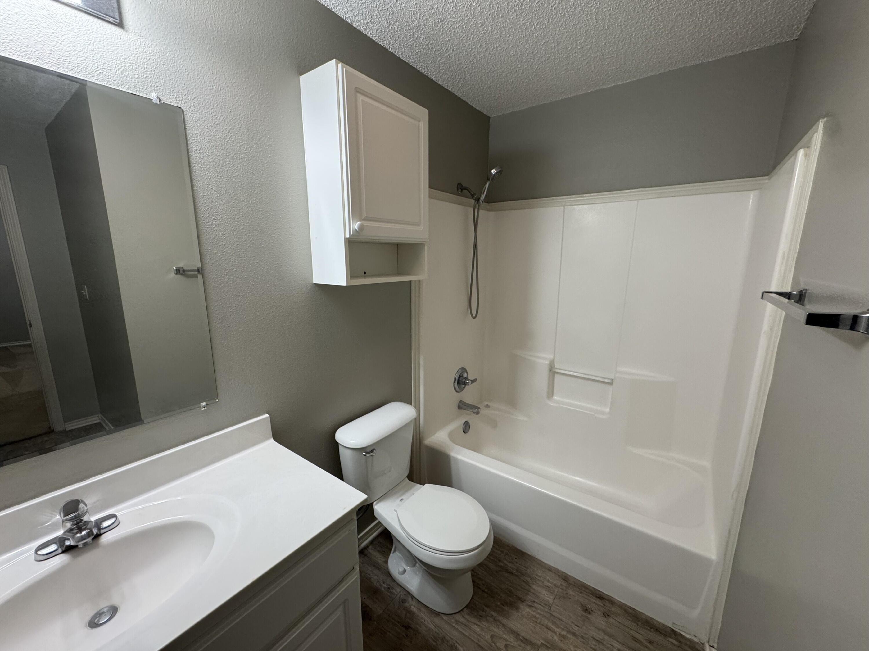5839 7th Street, Unit D Lubbock, TX 79416 - Photo 6 of 9 a bathroom with a sink toilet and shower