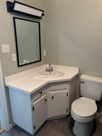 a bathroom with a toilet sink and mirror