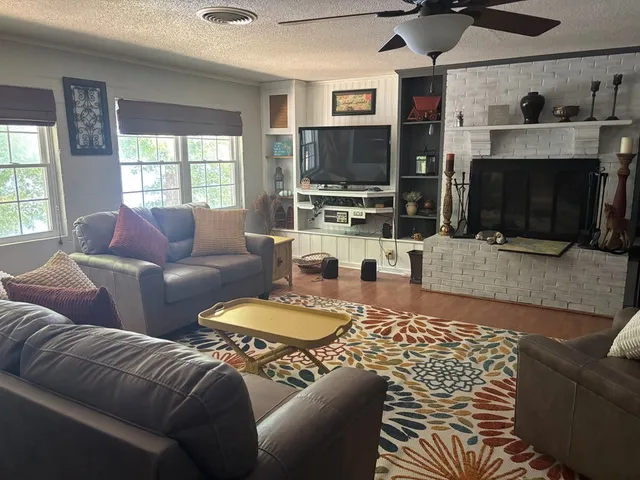 a living room with furniture a flat screen tv and a fireplace