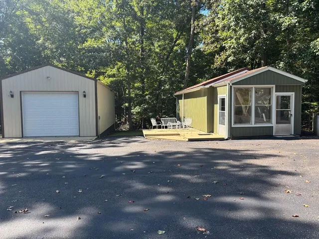a front view of a house with a yard and trees