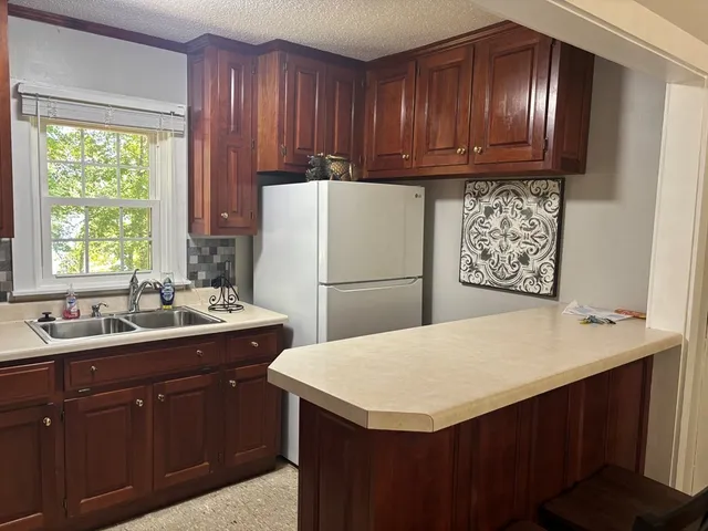 a kitchen with a sink a stove a refrigerator and a window