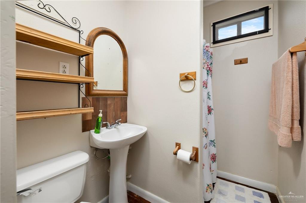 218 East Sam Houston Boulevard Pharr, TX 78577 - Photo 13 of 25 a bathroom with a sink toilet and a mirror