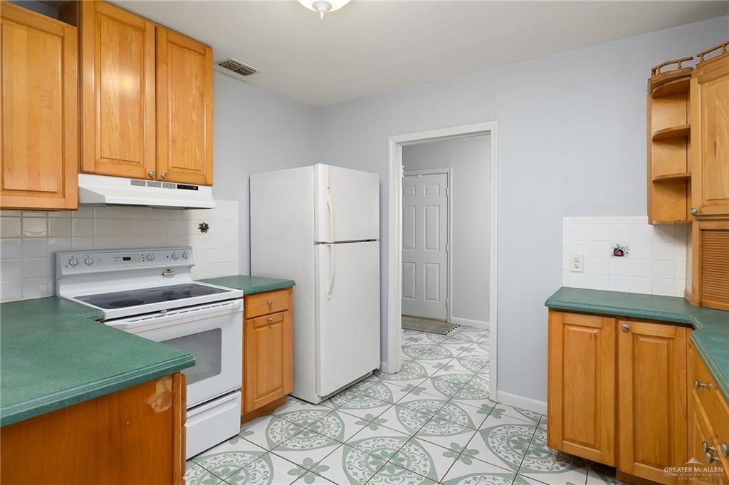218 East Sam Houston Boulevard Pharr, TX 78577 - Photo 7 of 25 a kitchen with stainless steel appliances granite countertop a refrigerator and a stove