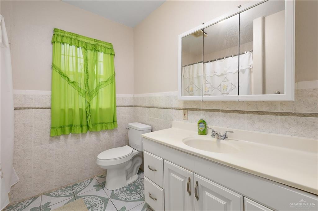 218 East Sam Houston Boulevard Pharr, TX 78577 - Photo 10 of 25 a bathroom with a sink a toilet and mirror