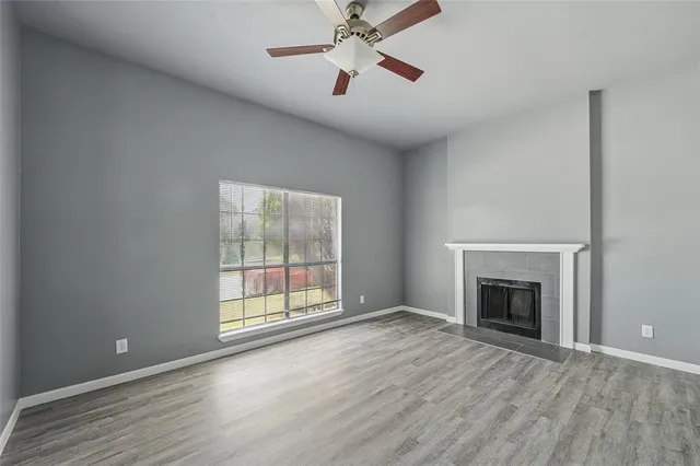 wooden floor fireplace and windows in an empty room